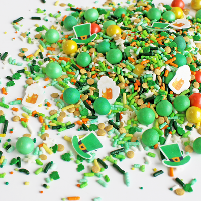 "Shenanigans Sprinkle Mix for St. Patrick's Day - vibrant green sprinkles with yellow and orange accents, featuring wafer paper beer mugs and leprechaun hats."